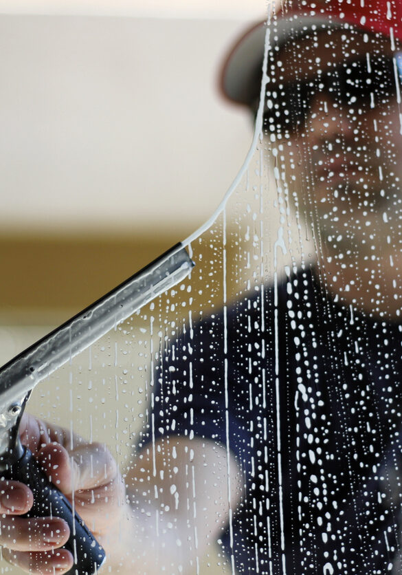 Worker using a squeegee to clean windows.